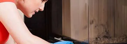 Person reinigt Kamin mit Schwamm