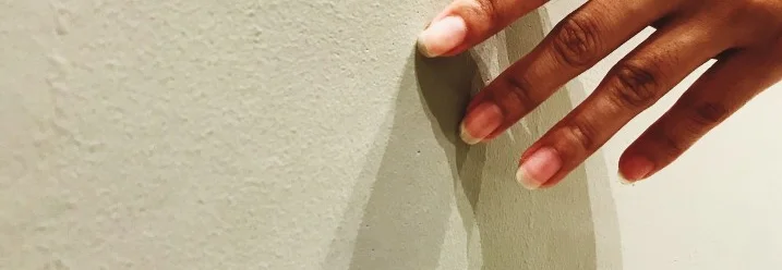 Hand berührt Wand