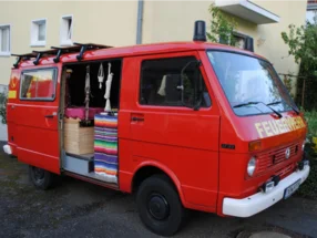 Roter Transporter, dessen Ladefläche als Wohnmobil ausgebaut ist