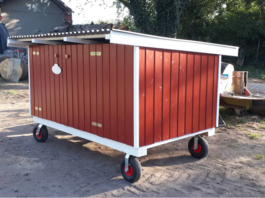Rotes Holzhaus auf Rädern
