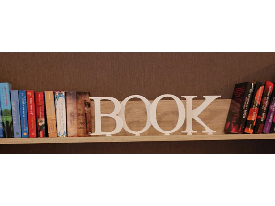 Dekobuchstaben mit der Aufschrift "BOOK" in einem Bücherregal