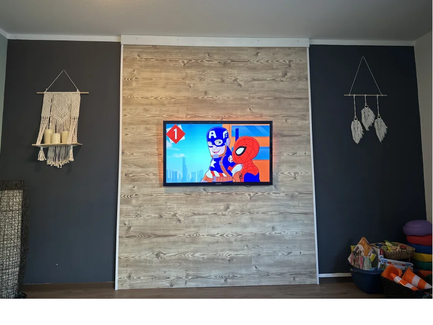 Fernseher an Holzwand mit Deko