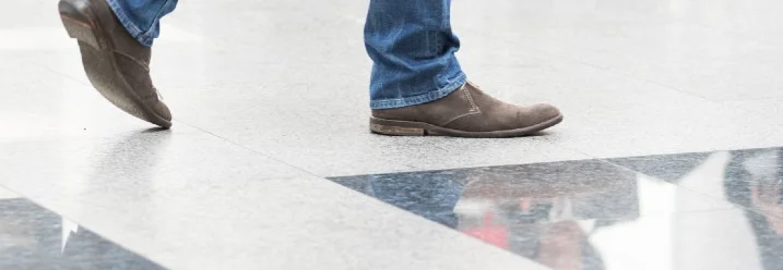 Eine Person läuft mit Schuhen auf Fliesenboden