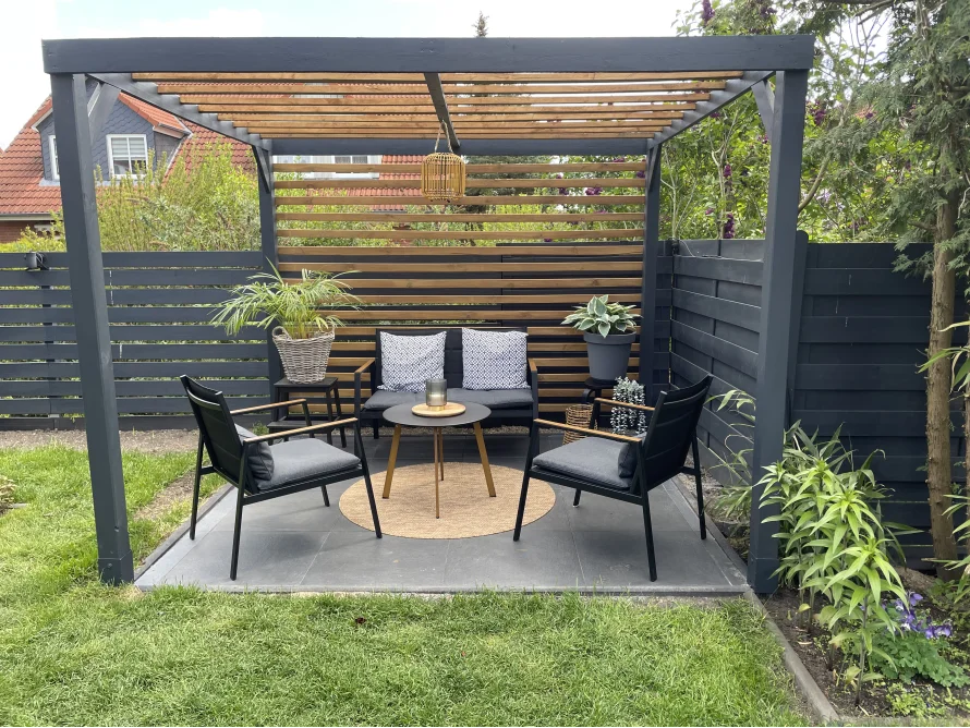 Gemütliche Sitzecke mit Lounge-Möbeln unter einer Pergola