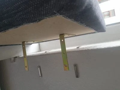 Zwei Winkel zur Befestigung eines Sitzfläche an einer Fensterbank.