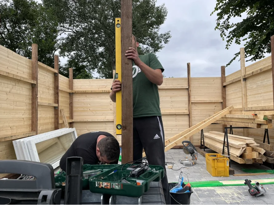 Zwei Personen bauen ein Gartenhaus