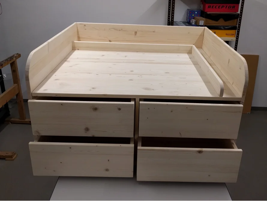Unbehandeltes Holzbett mit Schubladen