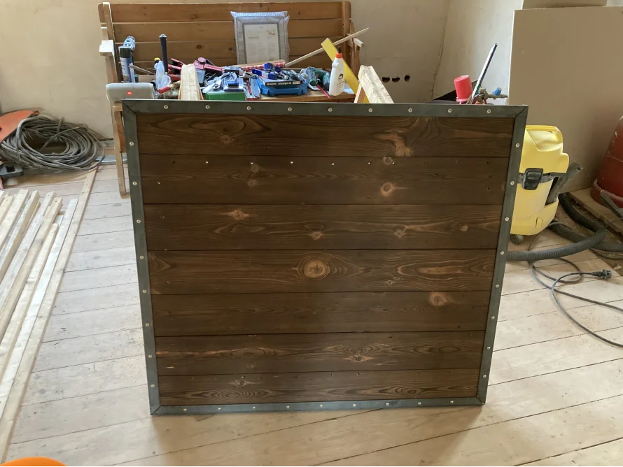 Dunkel gebeizte Holzplatte mit Metallrahmen