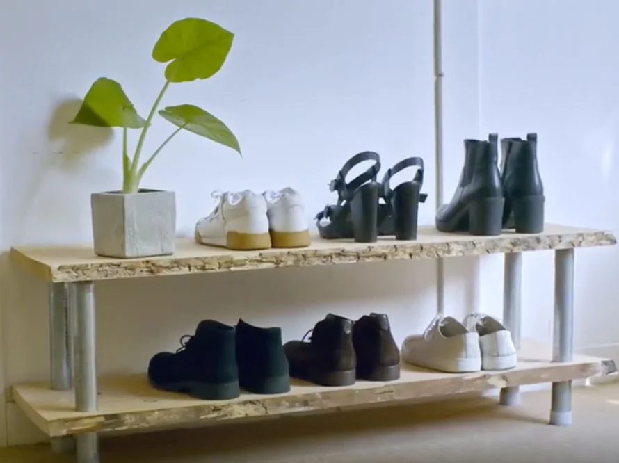 Rustikales Schuhregal aus Holz mit Schuhen und einer Pflanze