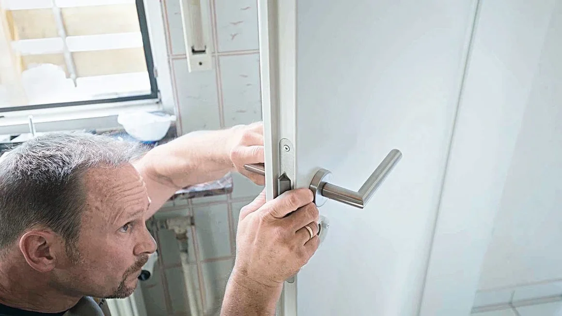 Person bringt Türklinke an.