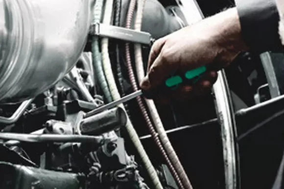 Hand schraubt an Motor