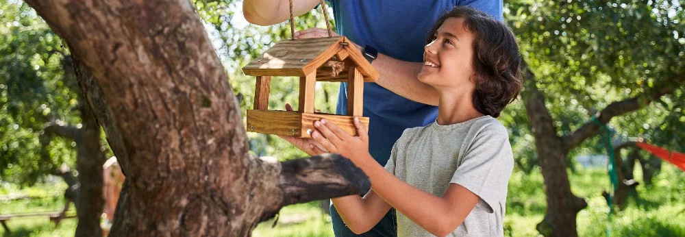 Kind hält Vogelfutterhaus