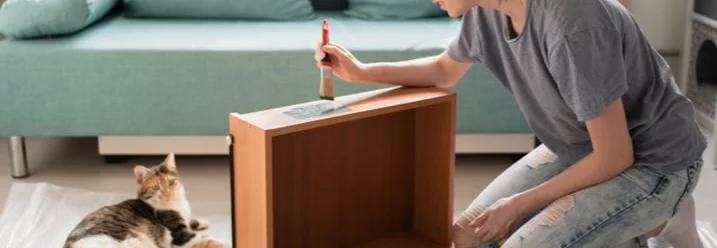 Person streicht Holzmöbel