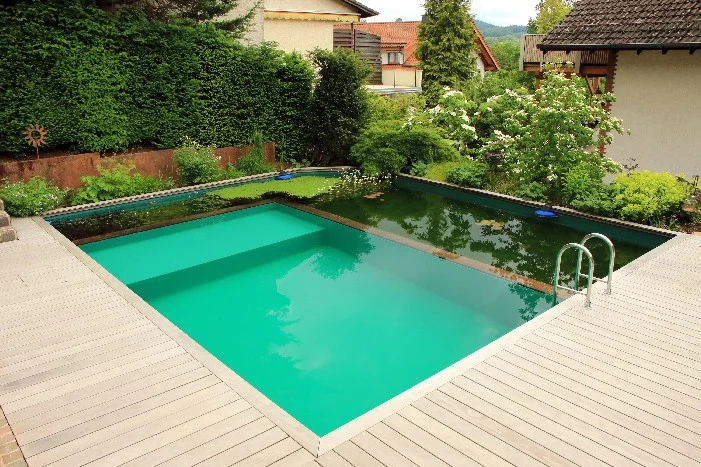 Moderner Gartenpool mit Filterbecken und Holzterrasse