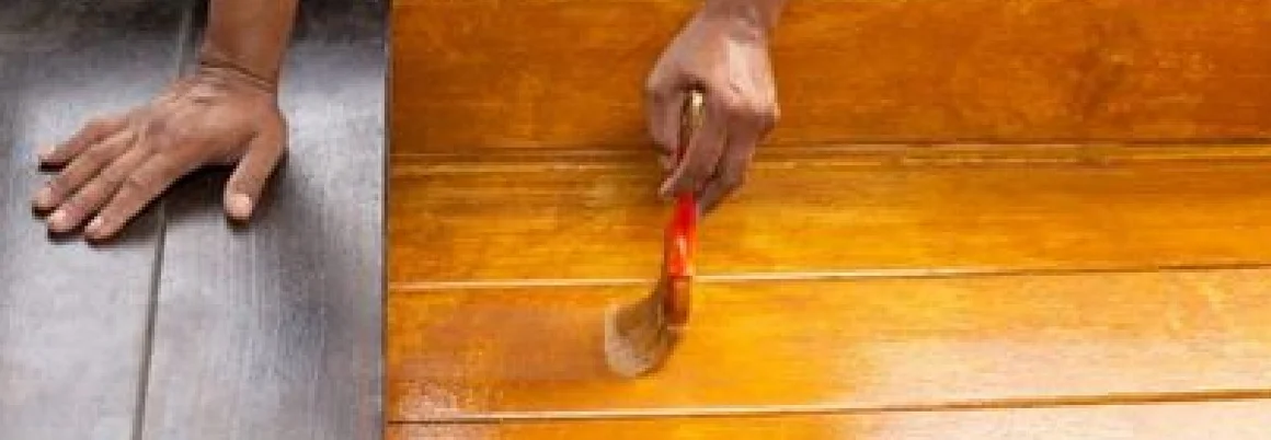Person streicht Holz mit Pinsel