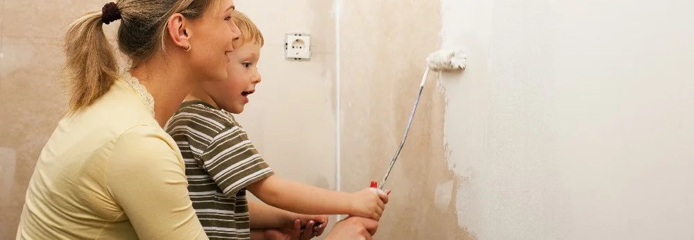 Kind und Person streichen Wand weiß
