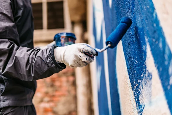 Person streicht Wand blau