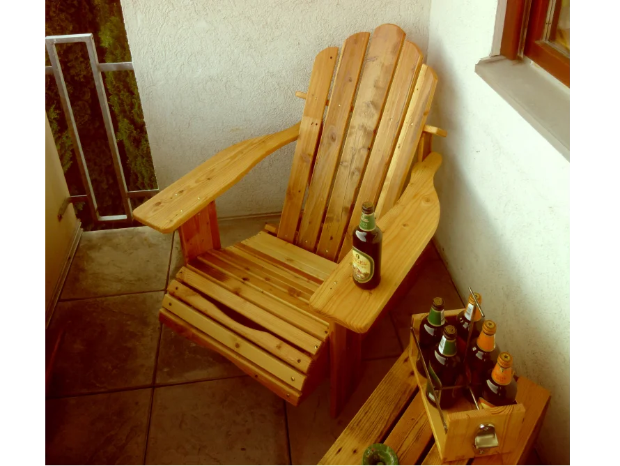 Holzliegestuhl auf Balkon mit Getränken