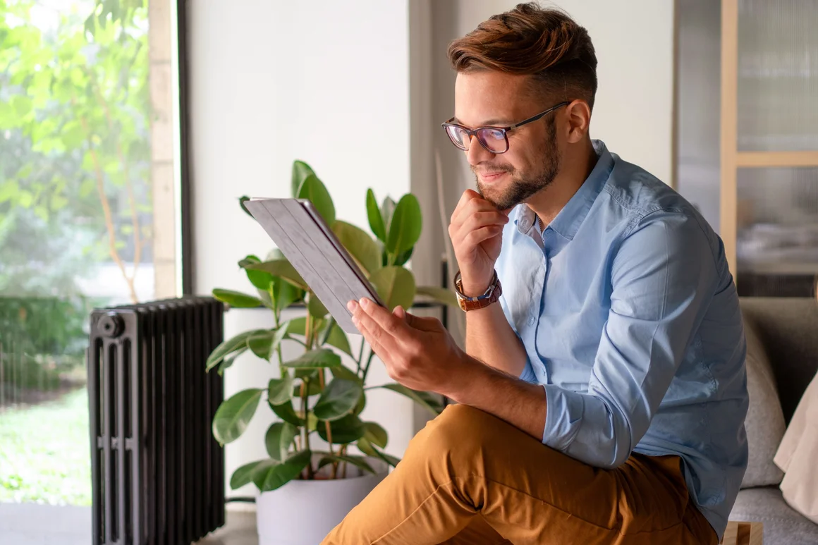 Person sitzt und liest auf einem Tablet