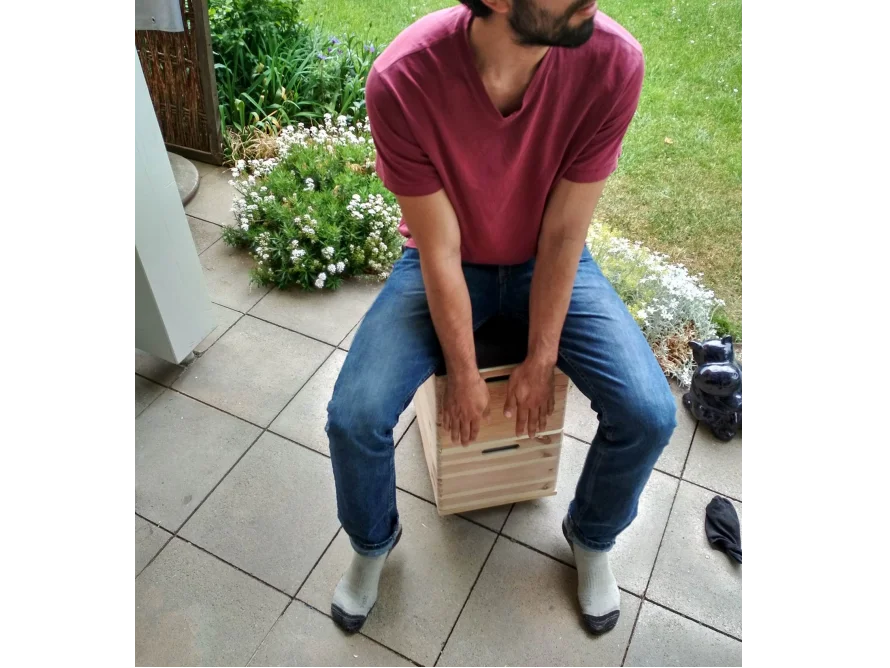 Person sitzt auf Holzkiste