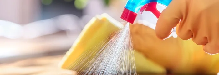 Hand in Gummihandschuh reinigt Oberfläche