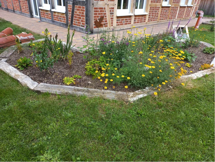 Blumenbeet vor Fachwerkhaus