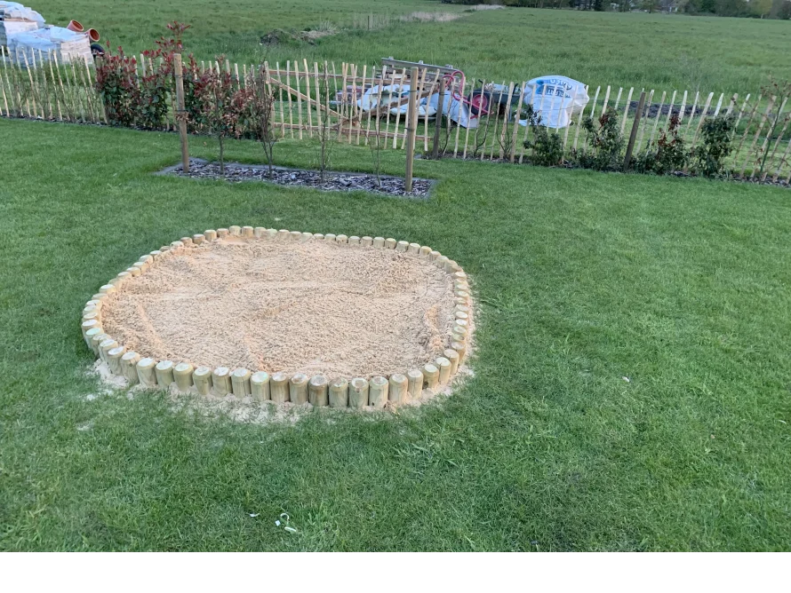 Sandkasten mit Holzumrandung im Garten