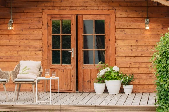 Gartenhaus aus Holz mit Terrasse und Stühlen