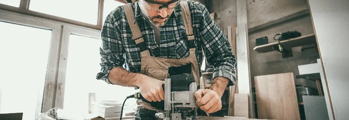 Person bearbeitet Holz mit Oberfräse