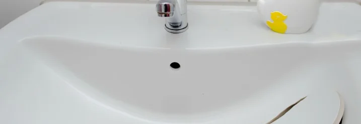 Ein weißes Waschbecken mit einem abgebrochenen Stück