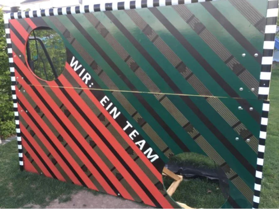 Bunte Holzwand mit zwei runden Öffnungen.