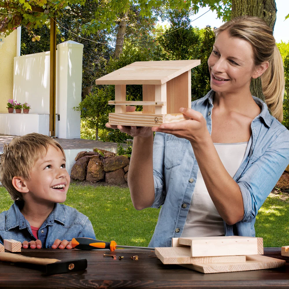 Person und Kind bauen ein Vogelhaus