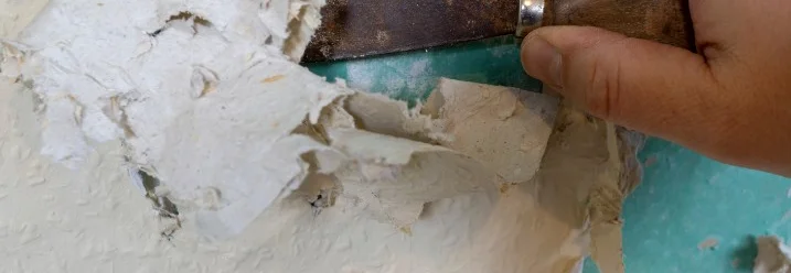 Hand entfernt Tapete mit Spachtel