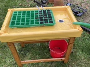 Holztisch mit Ausguss und Gießkanne