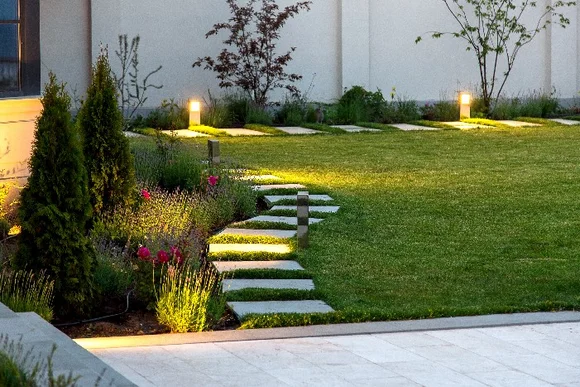 Beleuchteter Gartenweg mit mehreren Steinplatten