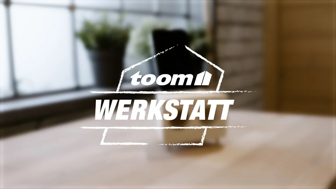 toom Werkstatt Logo mit unscharfem Lautsprecher im Hintergrund 