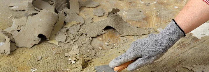 Hand entfernt Teppich mit Spachtel vom Boden