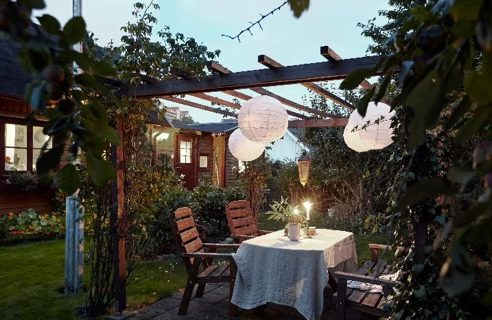 Gemütlicher Sitzplatz mit Tisch und Stühlen unter einer Pergola