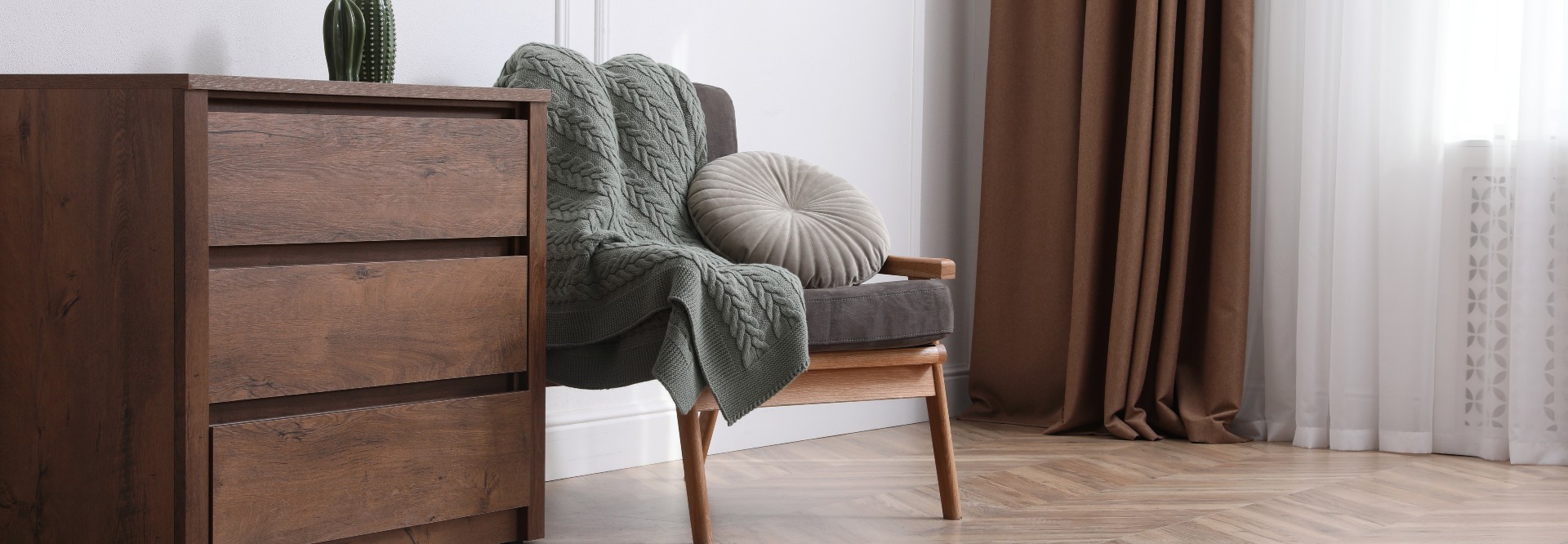 Gemütliche Ecke mit Kommode und Sessel.
