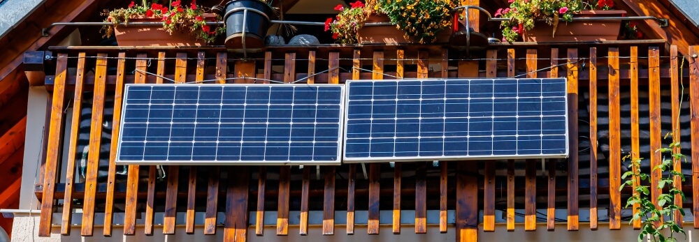 Zwei Solarmodule an einem Holzgeländer